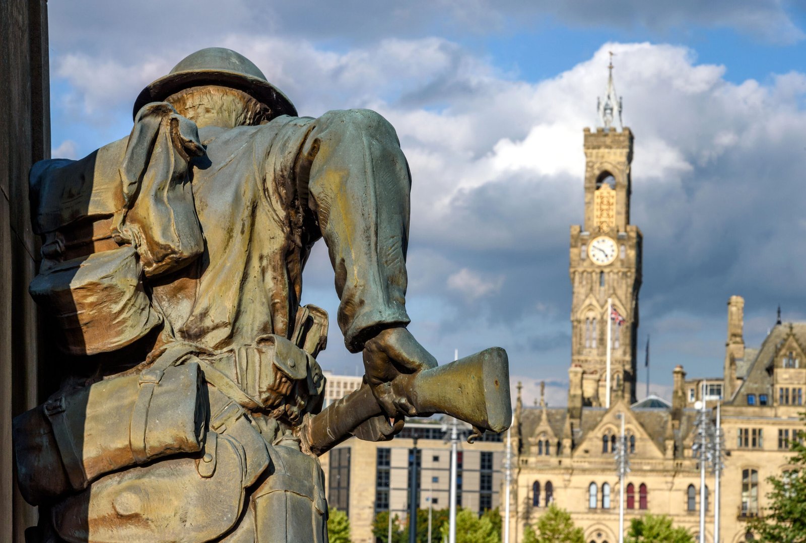 War Memorial Bradford UK depicting a bronze sculpture with city hall in its background